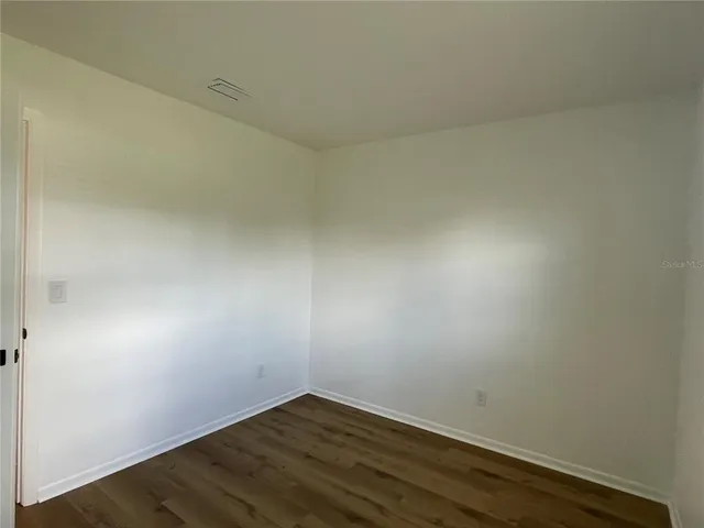an empty room with wooden floor
