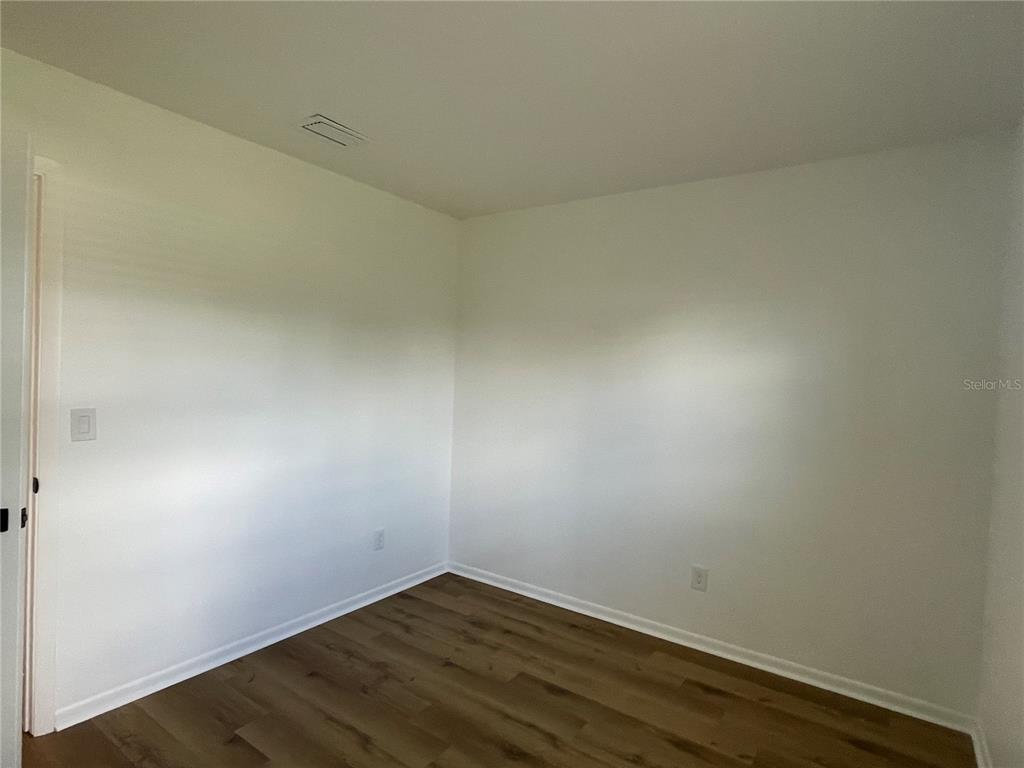 9244 Cyril Court Spring Hill, FL 34608 - Photo 22 of 30 an empty room with wooden floor