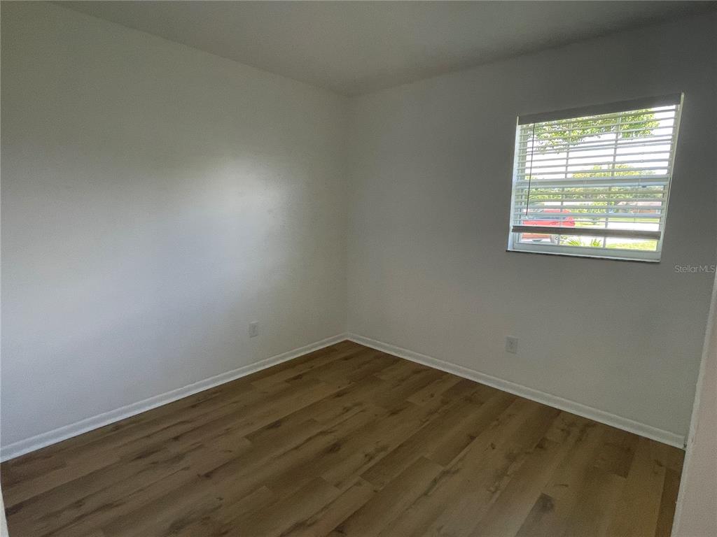 9244 Cyril Court Spring Hill, FL 34608 - Photo 24 of 30 an empty room with wooden floor and windows