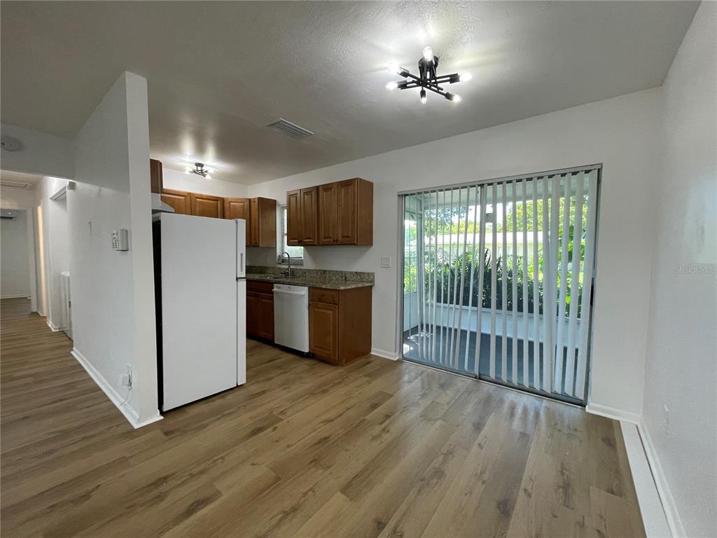 9244 Cyril Court Spring Hill, FL 34608 - Photo 7 of 30 a view of a kitchen with a fridge wooden floor and a window