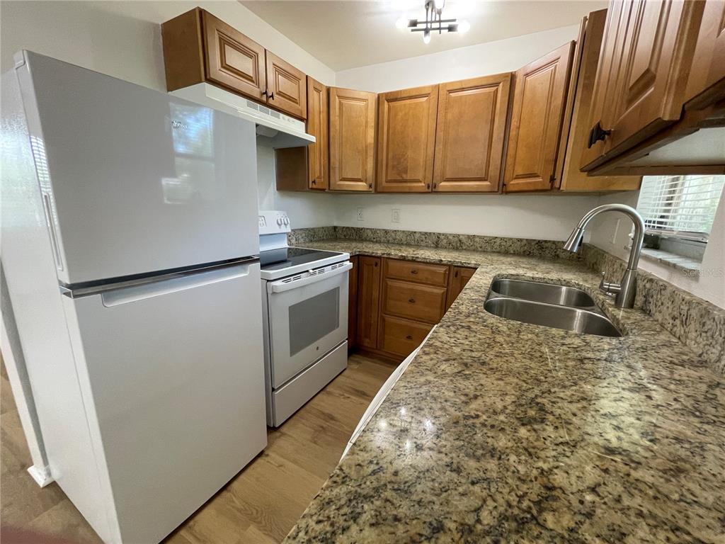 9244 Cyril Court Spring Hill, FL 34608 - Photo 10 of 30 a kitchen with a stove a sink and a microwave