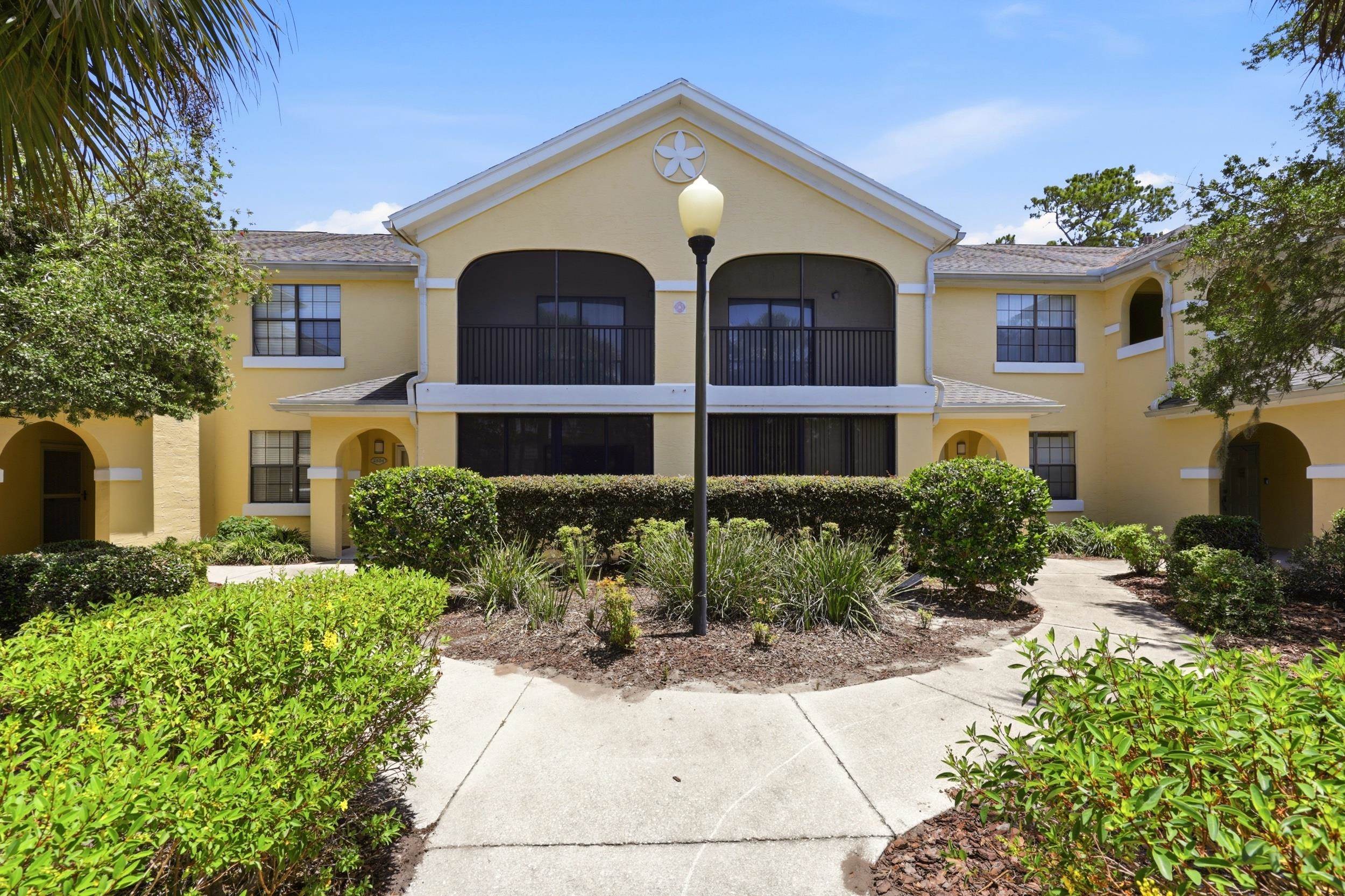 2500 Vista Cove Road St. Augustine, FL 32084 - Photo 45 of 53 a view of a white house with large windows and flower plants