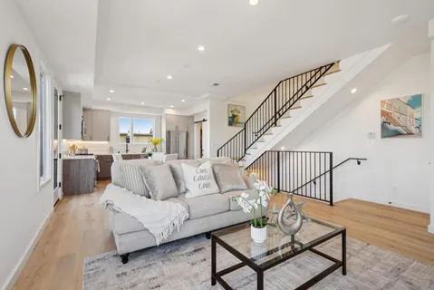 a kitchen with stainless steel appliances a refrigerator a stove a sink a dining table and chairs