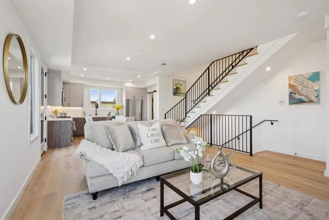 a kitchen with stainless steel appliances a refrigerator a stove a sink a dining table and chairs