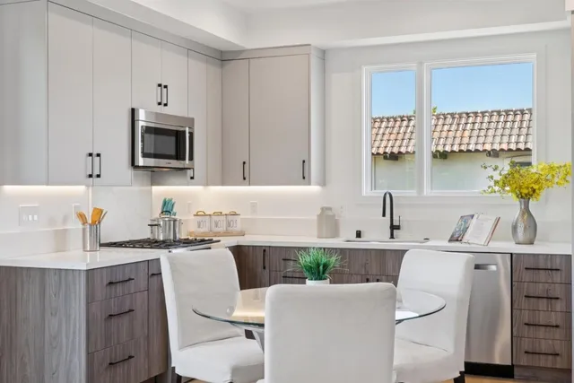 a kitchen with a dining table chairs and white cabinets