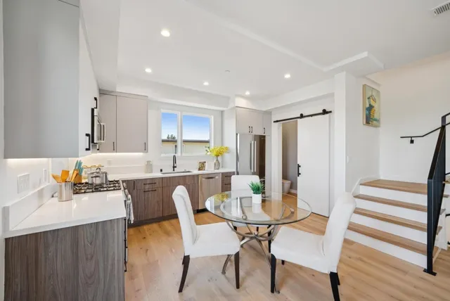 a kitchen with stainless steel appliances a stove a sink a microwave and a refrigerator