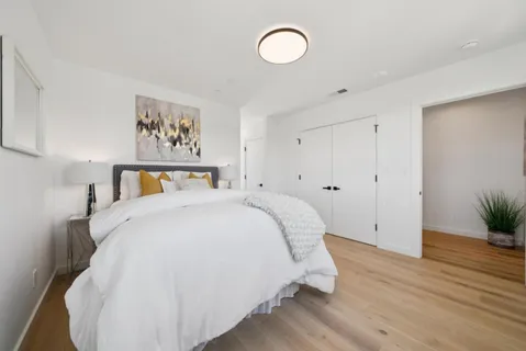 a bedroom with a bed and a potted plant