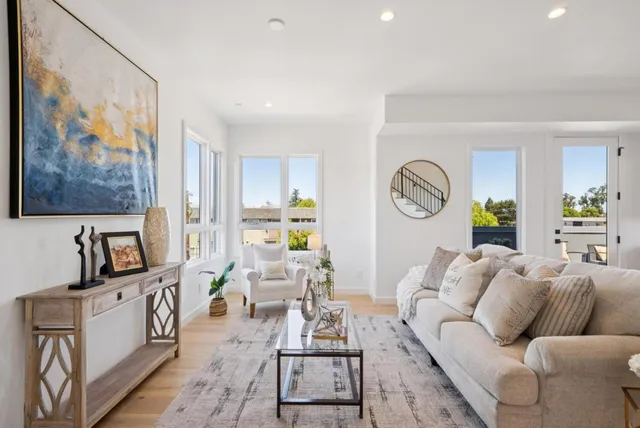 a living room with furniture kitchen view and a window