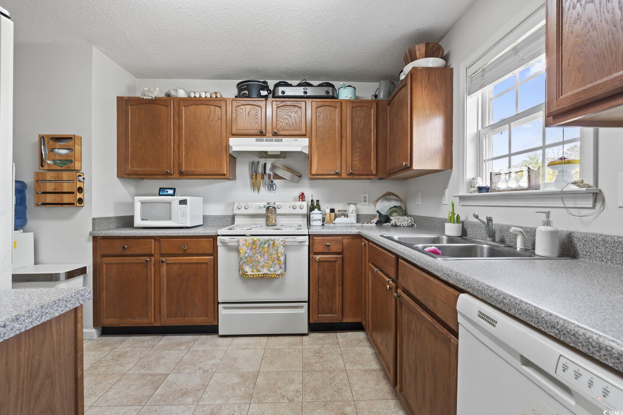 7530 Maple Swamp Road Gresham, SC 29546 - Photo 9 of 40 Kitchen with a sink, brown cabinets, white applian