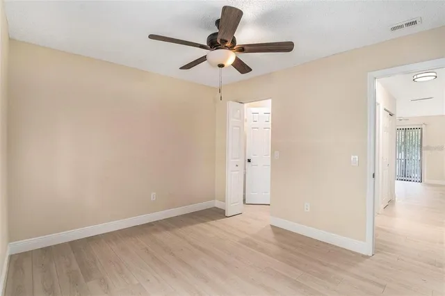 a view of room with a ceiling fan and wooden floor