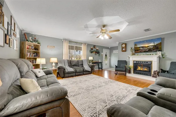 a living room with furniture a fireplace and a flat screen tv