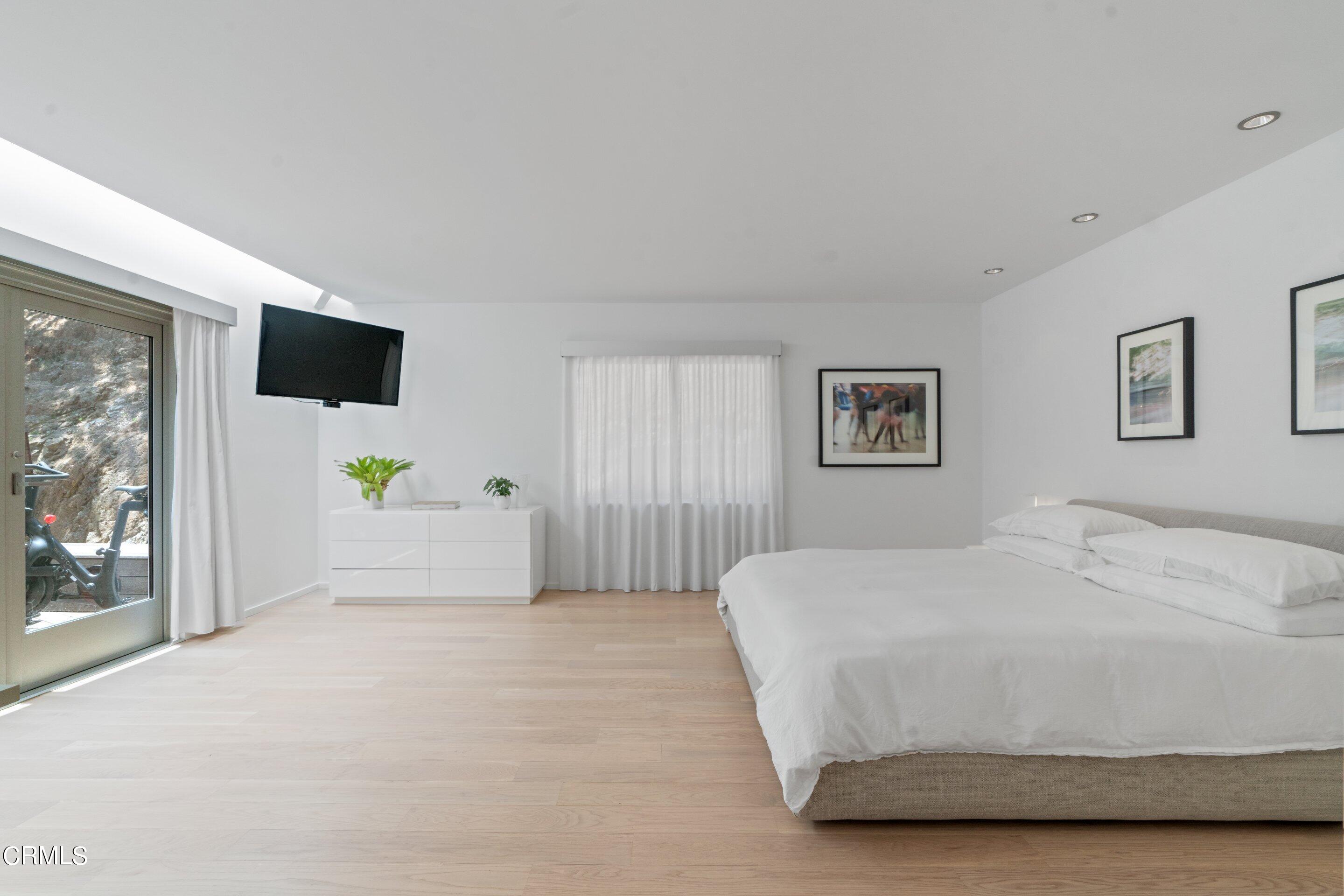 1460 Linda Ridge Road Pasadena, CA 91105 - Photo 34 of 63 a spacious bedroom with a bed and a flat screen tv