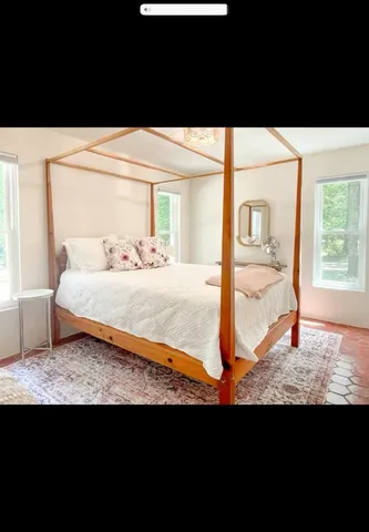 a view of a bedroom with furniture and window