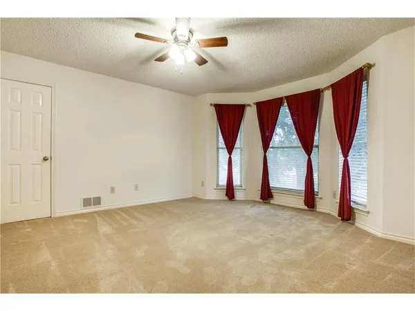 a view of empty room with a ceiling fan