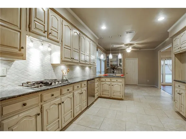 a kitchen with granite countertop a sink stainless steel appliances and cabinets