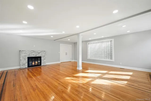 a view of an empty room with window and fire place