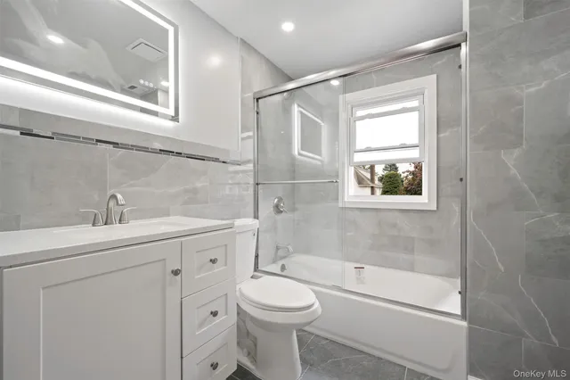 a bathroom with a toilet a sink a mirror and a bathtub