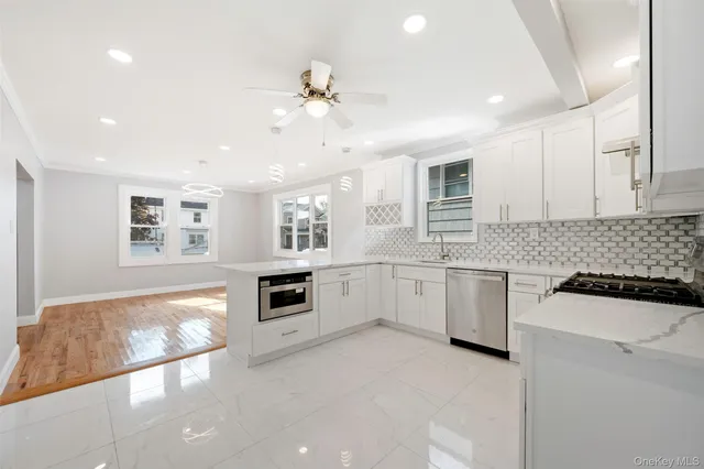 a kitchen with granite countertop a stove top oven a sink a counter space and cabinets