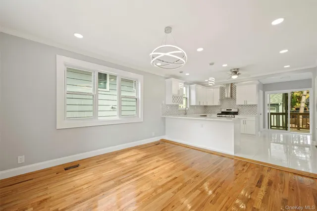 a view of a kitchen with wooden floor and a window