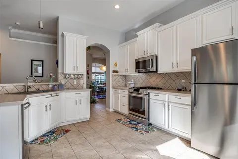 a kitchen with granite countertop a refrigerator stove top oven and sink