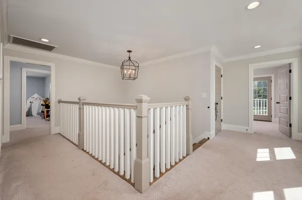 a view of a hallway with wooden floor and staircase