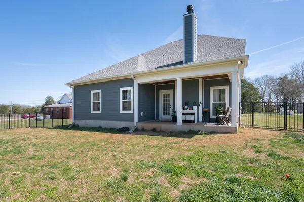 a view of a house with a yard and sitting area