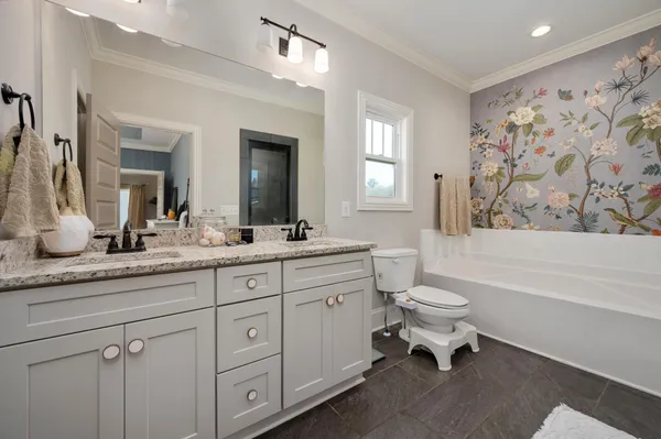 a spacious bathroom with a granite countertop sink a toilet and a bathtub