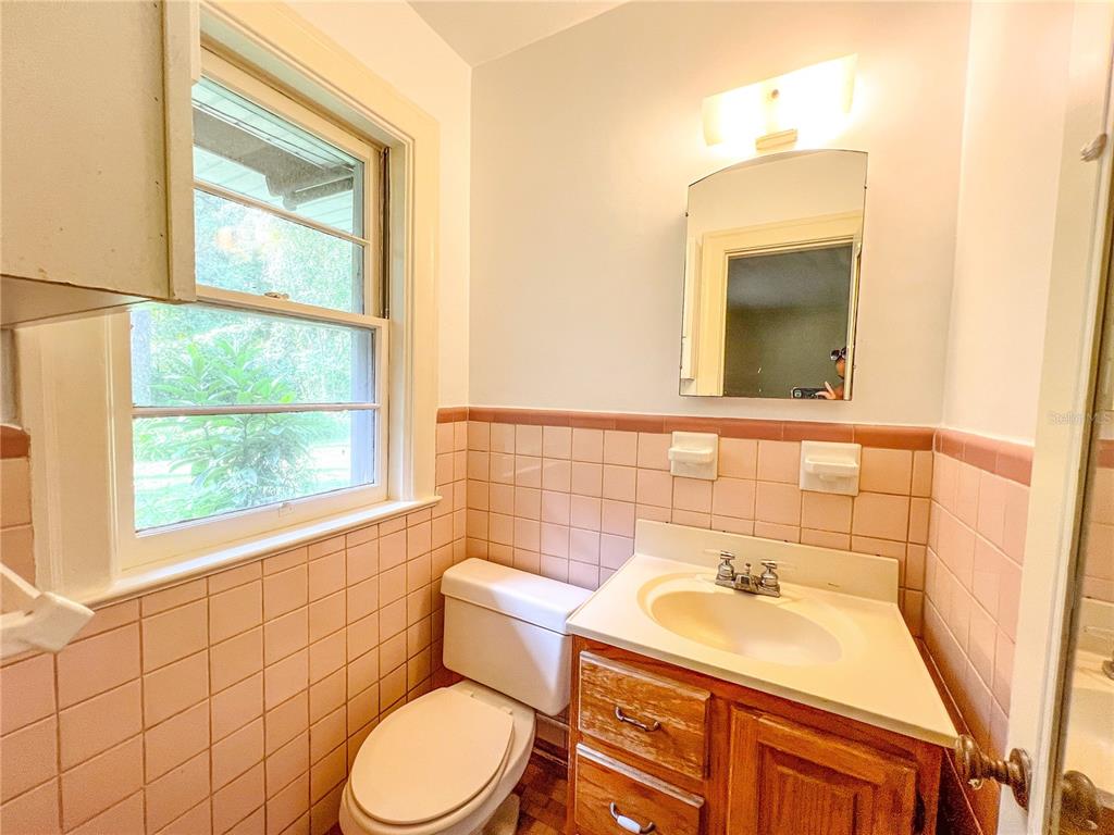 1403 Northwest 11th Road Gainesville, FL 32605 - Photo 12 of 15 a bathroom with a sink a toilet and mirror