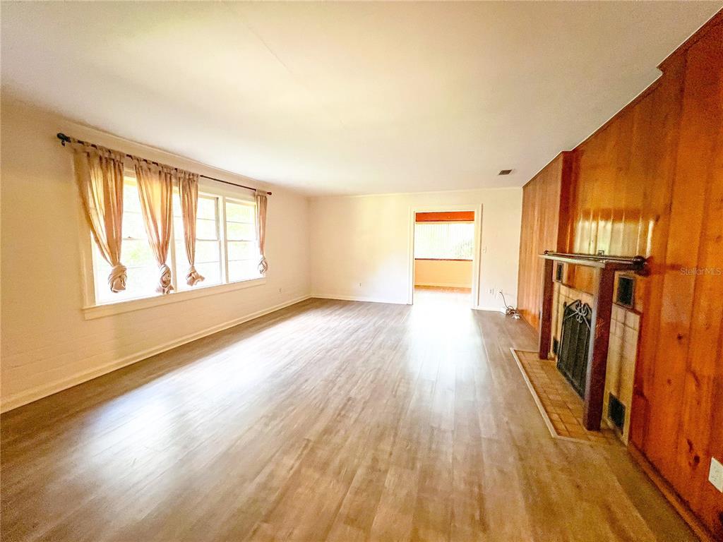 1403 Northwest 11th Road Gainesville, FL 32605 - Photo 3 of 15 a view of empty room with wooden floor and fan