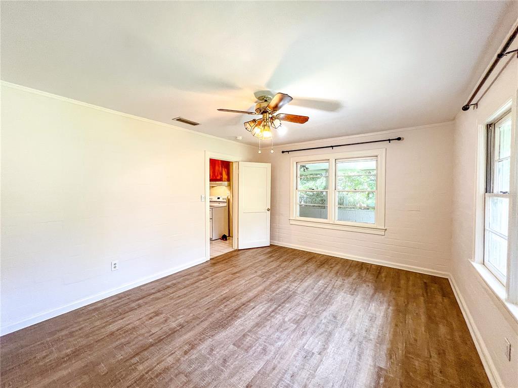 1403 Northwest 11th Road Gainesville, FL 32605 - Photo 5 of 15 an empty room with wooden floor and windows