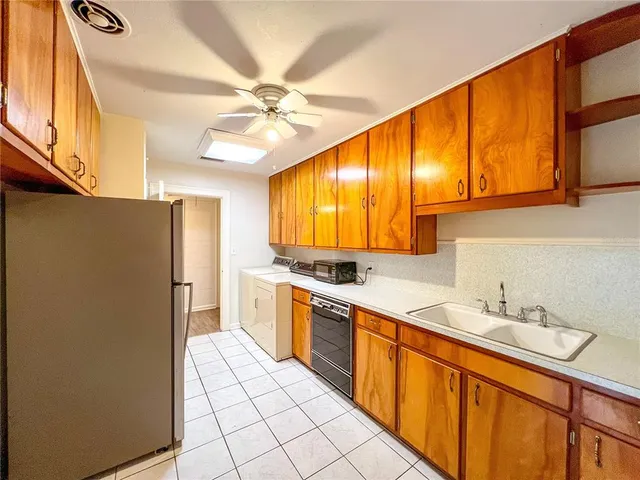 a kitchen with stainless steel appliances a sink cabinets and a refrigerator