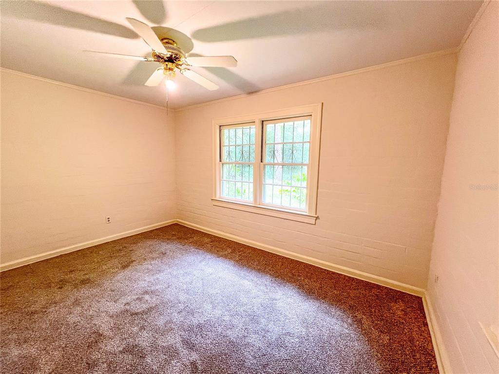 1403 Northwest 11th Road Gainesville, FL 32605 - Photo 10 of 15 an empty room with windows and fan