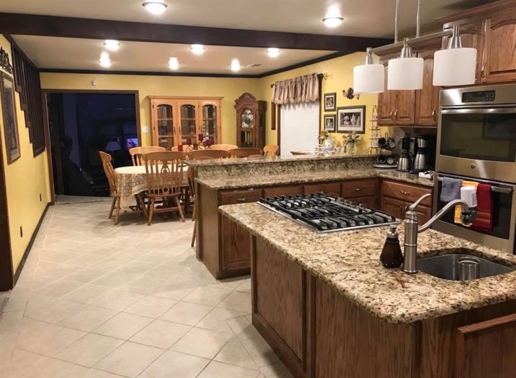 2924 Windsor Avenue Waco, TX 76708 - Photo 10 of 25 Granite countertops, integrated gas cooktop, stainless steel built-in oven, pendant lighting, and recessed ceiling lighting