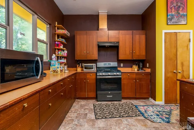 a kitchen with stainless steel appliances a stove a sink and a microwave