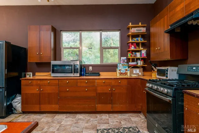 a kitchen with stainless steel appliances granite countertop a stove a sink and a microwave