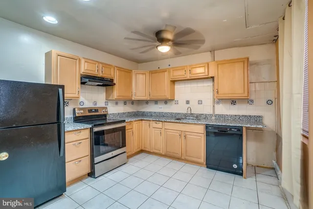 a kitchen with granite countertop stainless steel appliances a sink and a refrigerator
