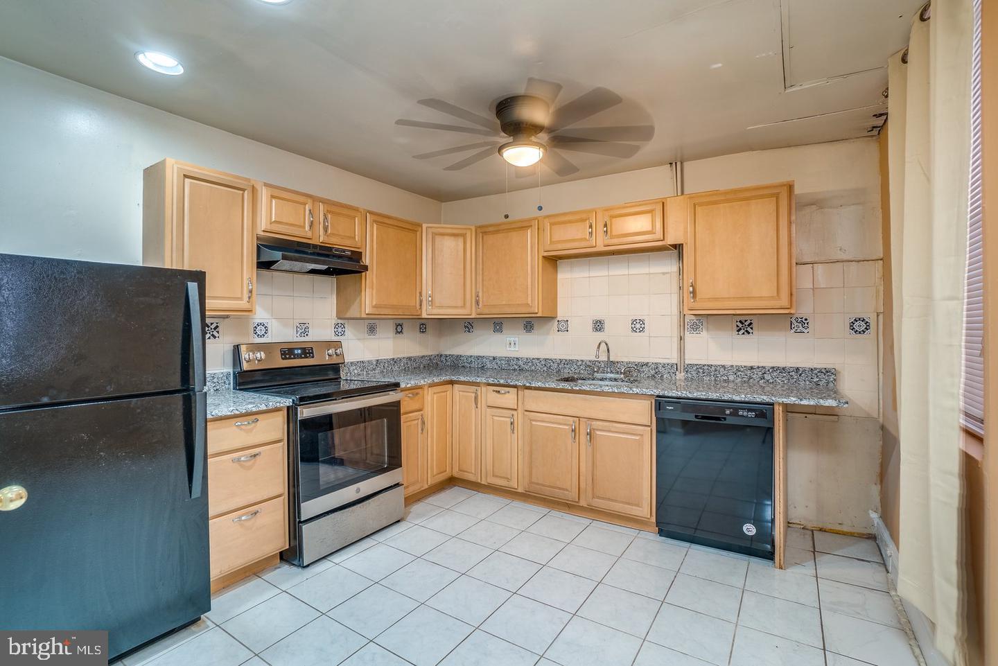1420 Light Street, Unit 1R Baltimore, MD 21230 - Photo 6 of 8 a kitchen with granite countertop stainless steel appliances a sink and a refrigerator
