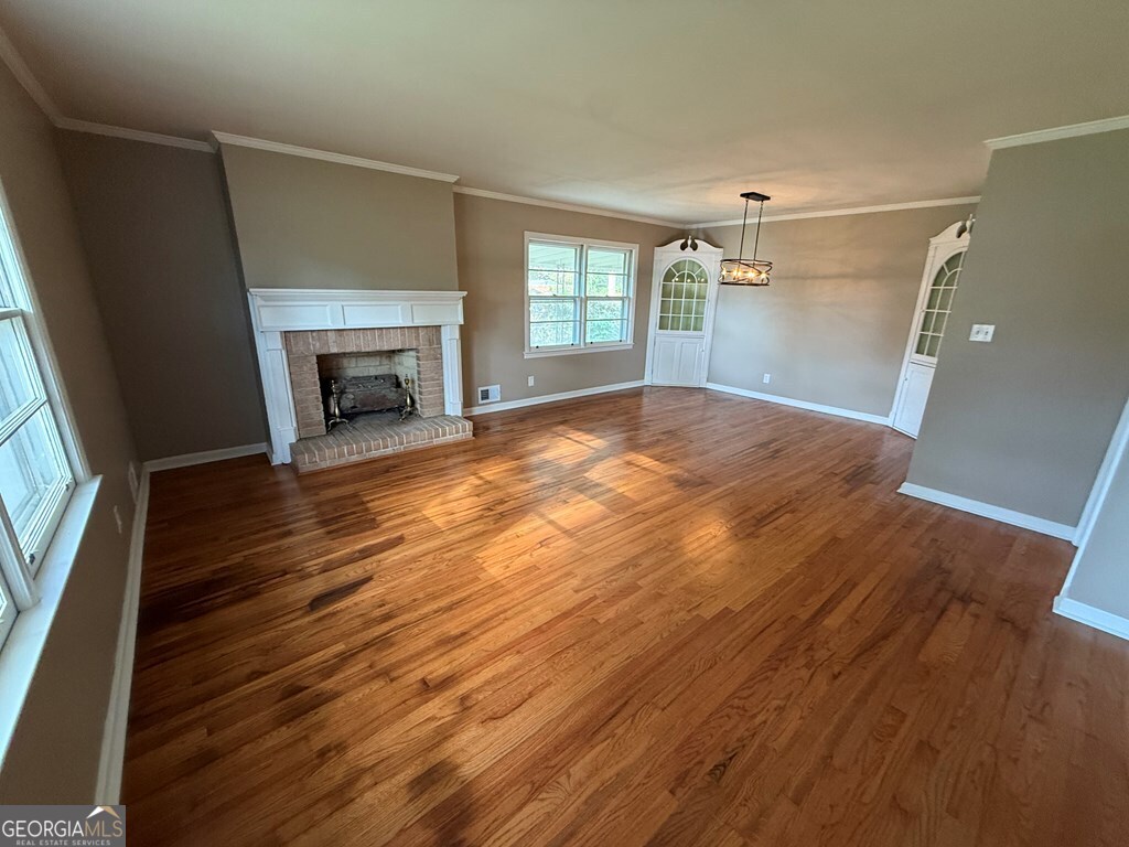 412 Roberson Street Dublin, GA 31021 - Photo 20 of 54 a view of empty room with wooden floor and fireplace