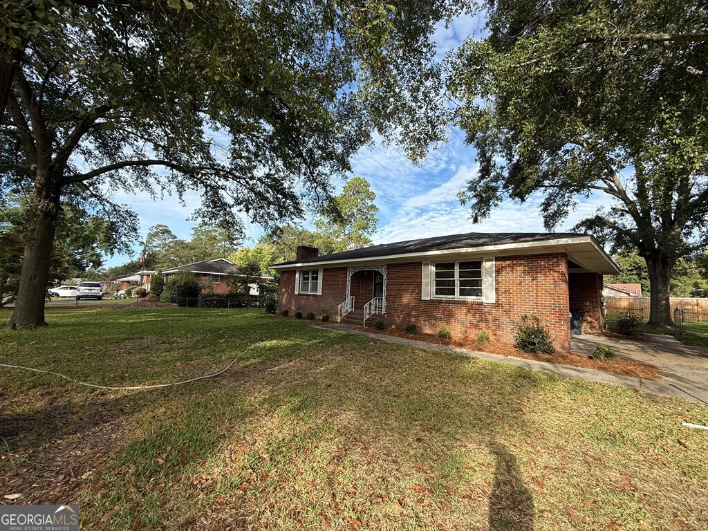 412 Roberson Street Dublin, GA 31021 - Photo 3 of 54 a view of a yard in front of a house with large trees