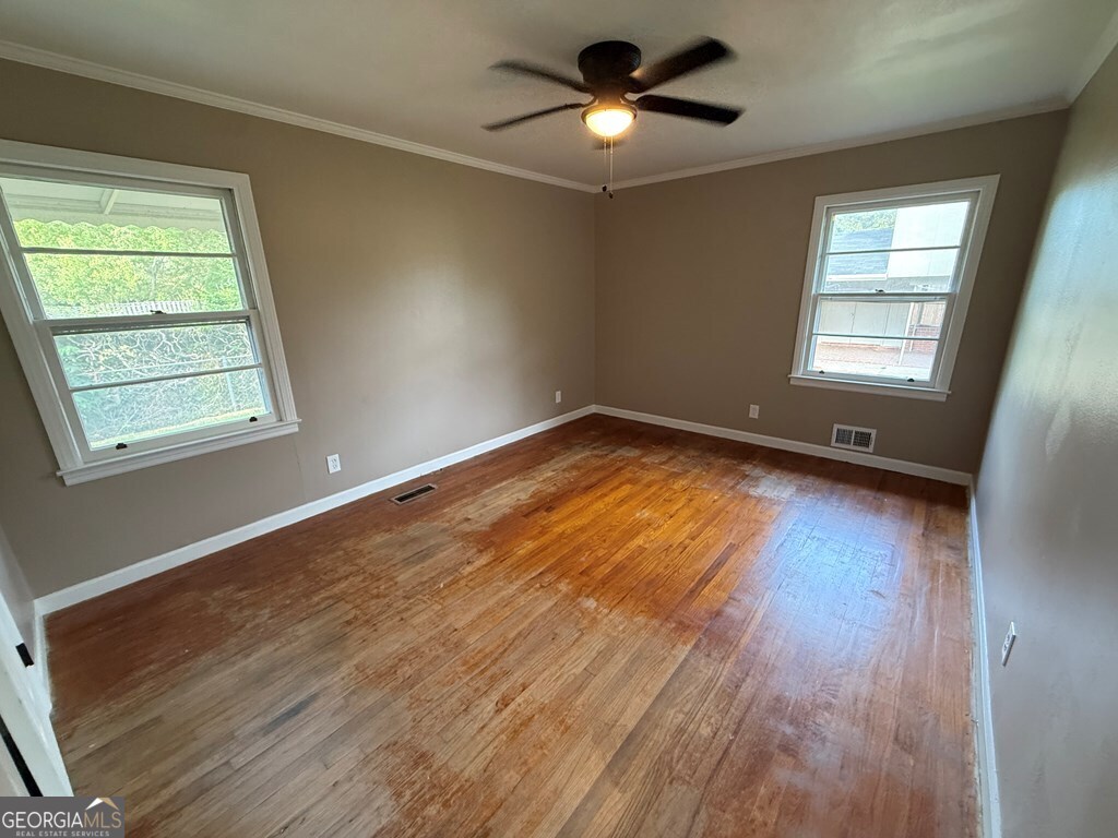 412 Roberson Street Dublin, GA 31021 - Photo 32 of 54 a view of empty room with wooden floor and fan