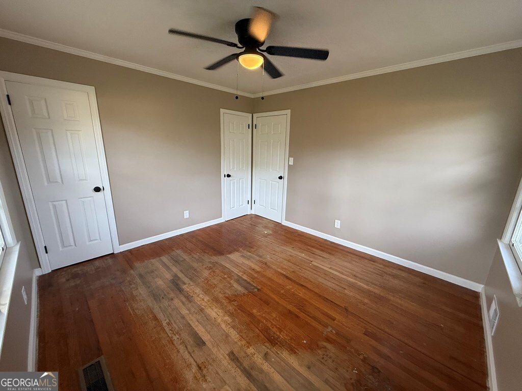 412 Roberson Street Dublin, GA 31021 - Photo 37 of 54 a view of a room with wooden floor and a ceiling fan