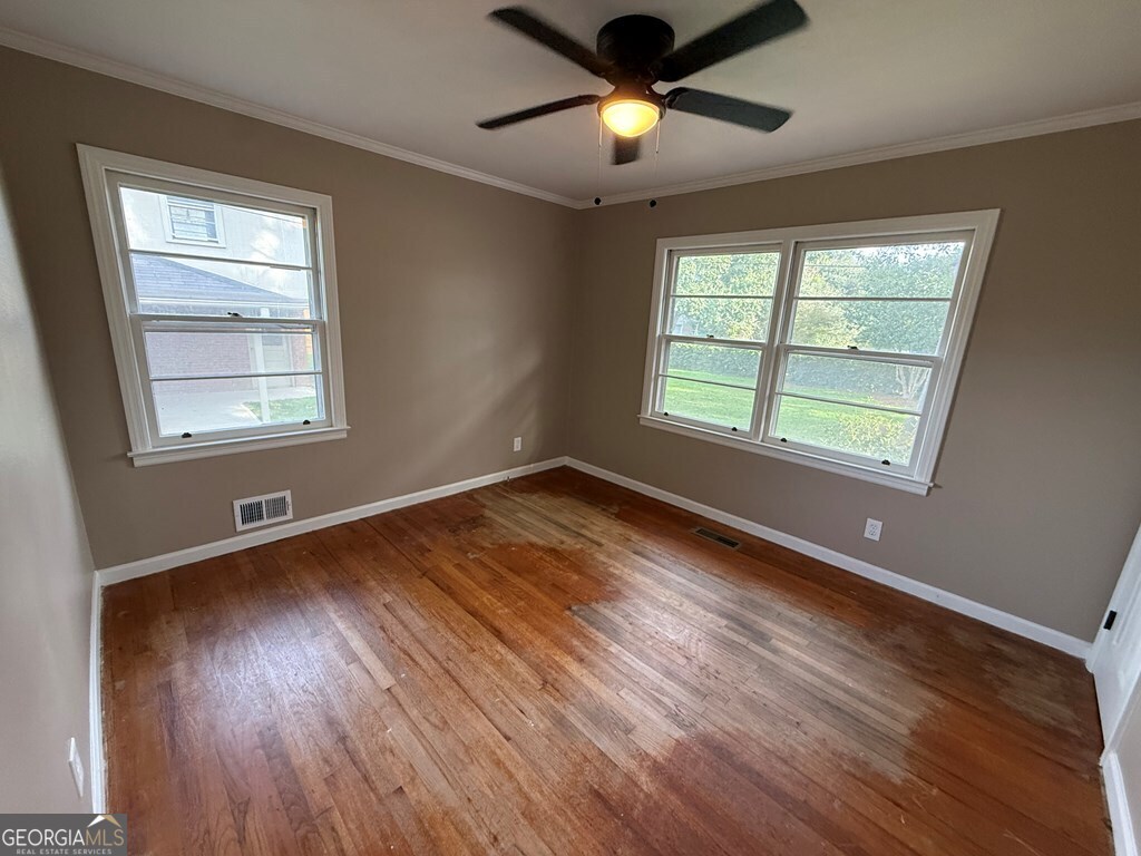 412 Roberson Street Dublin, GA 31021 - Photo 38 of 54 a view of an empty room with wooden floor and a window