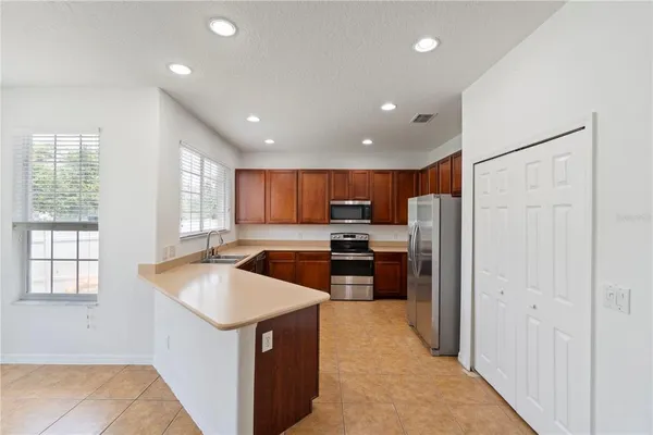 a kitchen with stainless steel appliances granite countertop a refrigerator and a sink