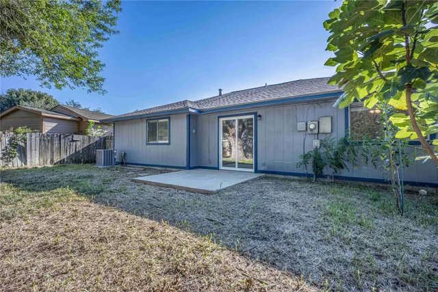 a view of a house with a yard and tree