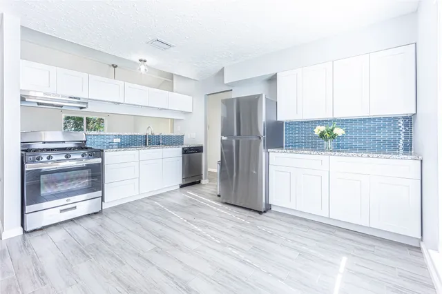 a kitchen with stainless steel appliances a refrigerator sink and cabinets