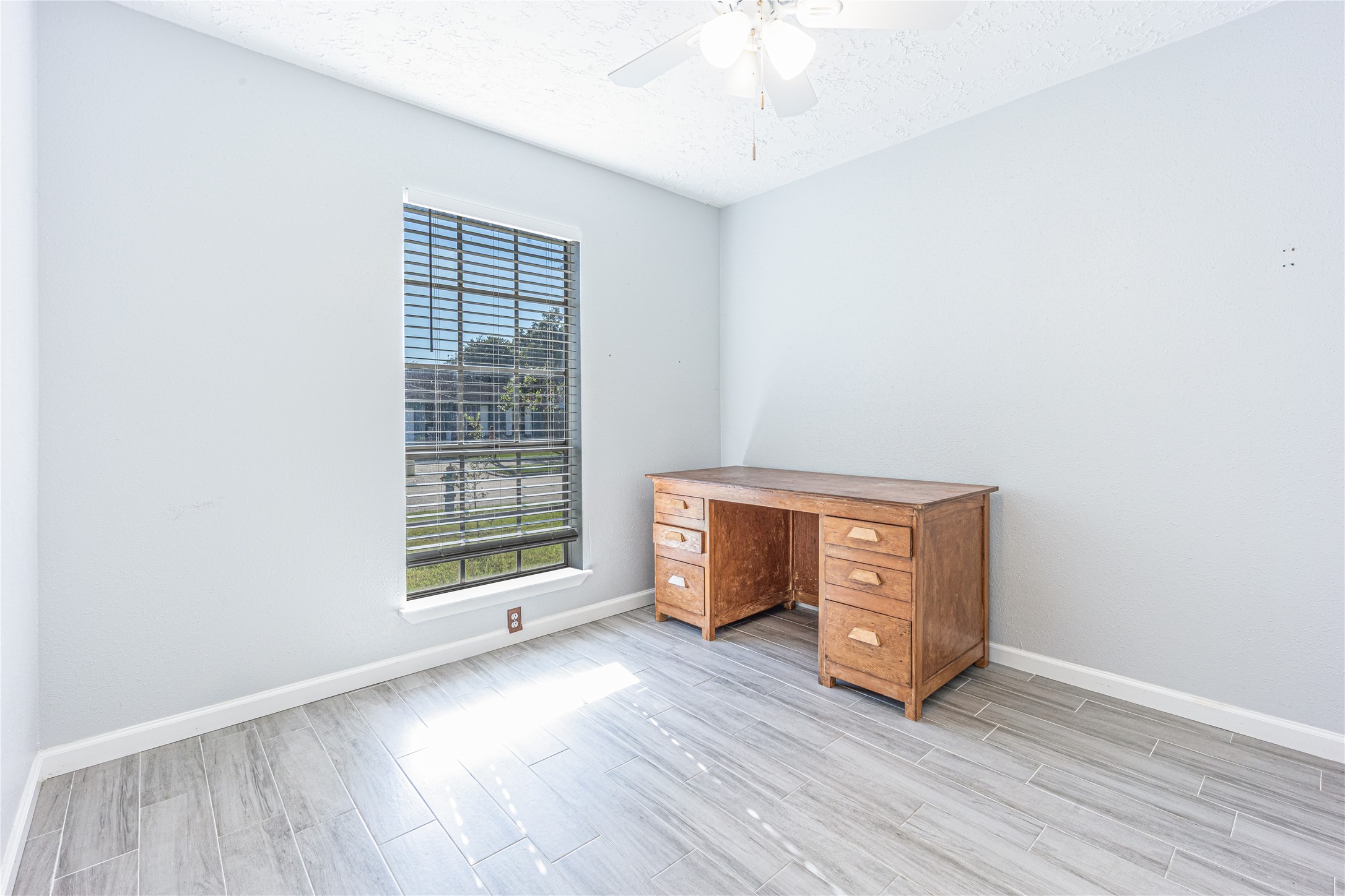1010 Woodbridge Avenue Pearland, TX 77584 - Photo 8 of 14 a view of an empty room with a window and wooden floor