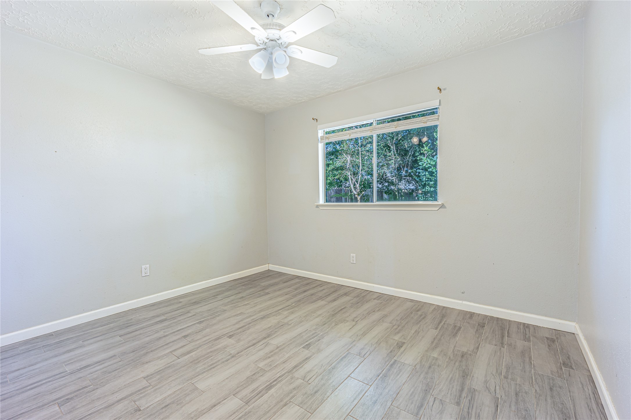 1010 Woodbridge Avenue Pearland, TX 77584 - Photo 9 of 14 a view of an empty room with wooden floor and a window