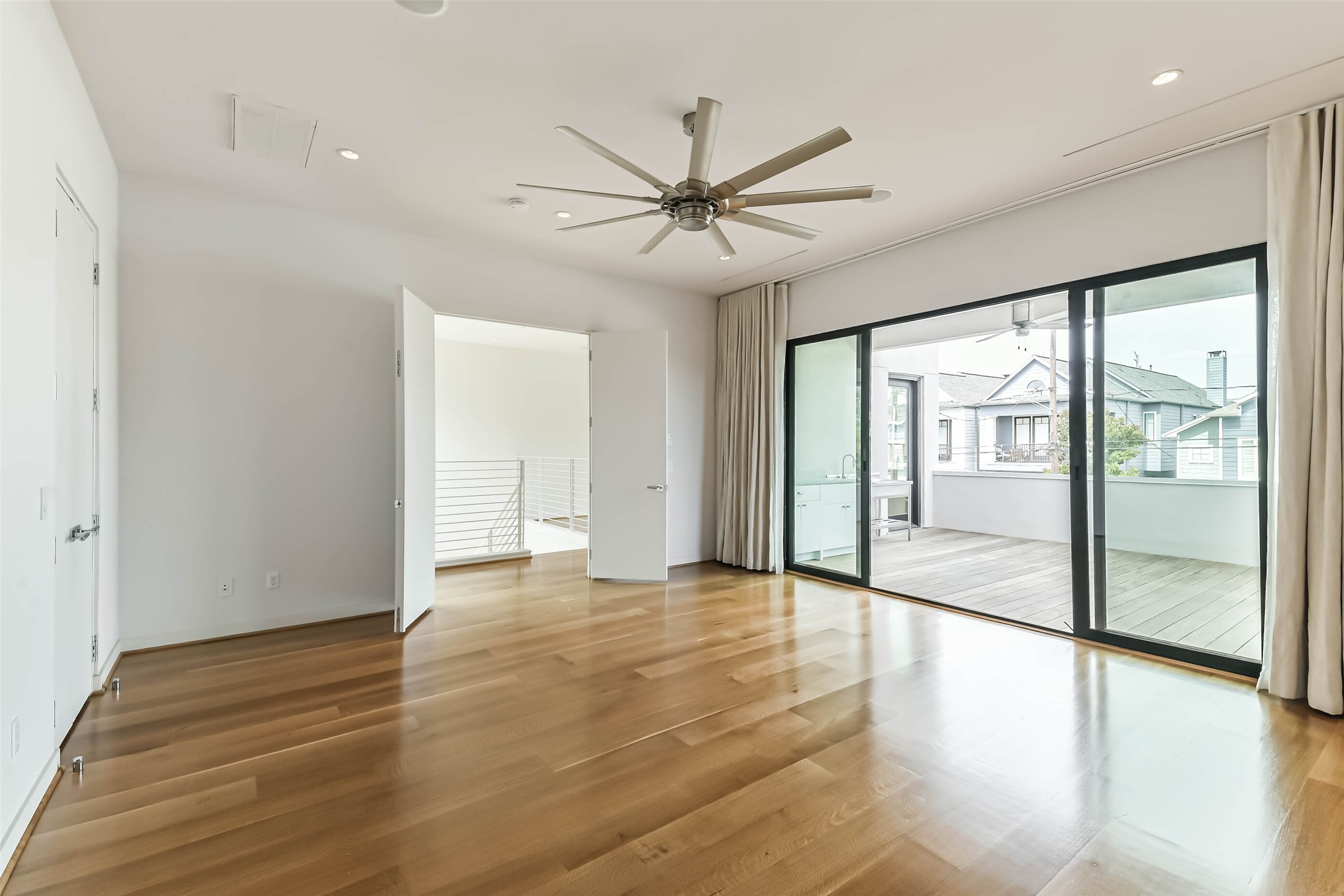 815 Alexander Street Houston, TX 77007 - Photo 31 of 49 Luxurious primary suite offers a spacious retreat with beautiful hardwood floors, soaring ceilings, recessed lighting, and a dramatic oversized ceiling fan.