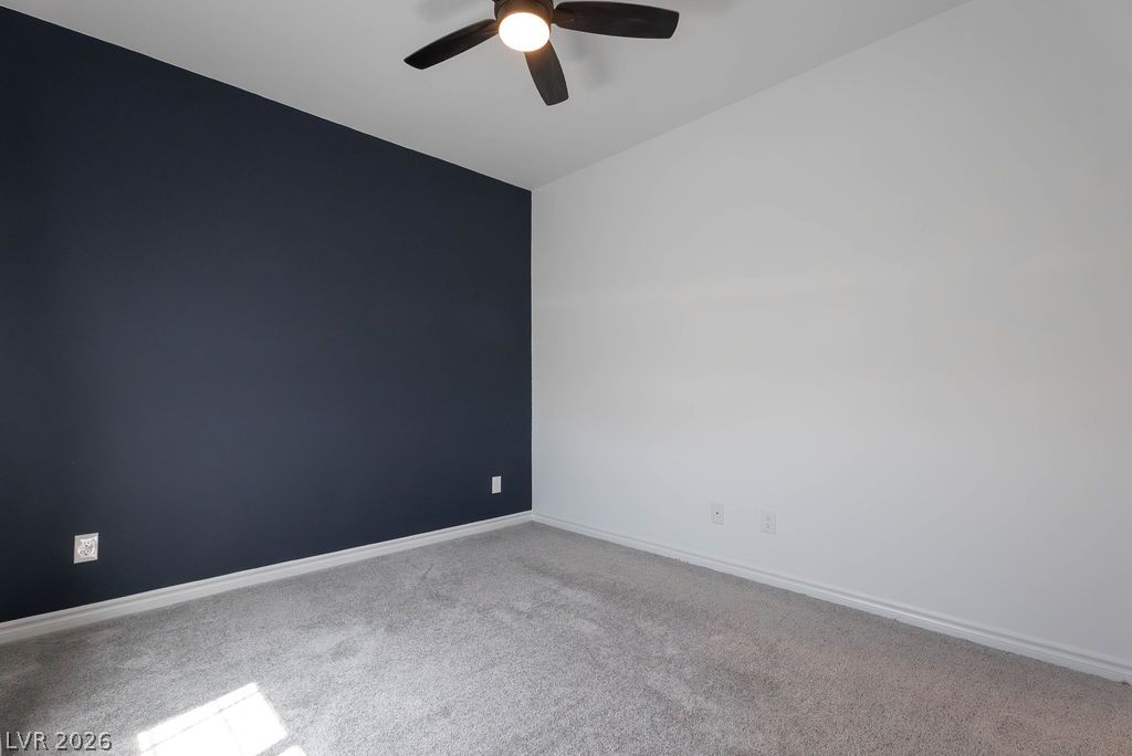 7126 Calvert Cliffs Street North Las Vegas, NV 89084 - Photo 35 of 44 An inviting room features a ceiling fan, plush carpeting, and a striking accent wall.