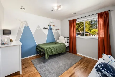 a bedroom with a bed and wooden floor